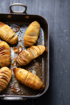 close up of a tray of rustic hasselback baked potatoes