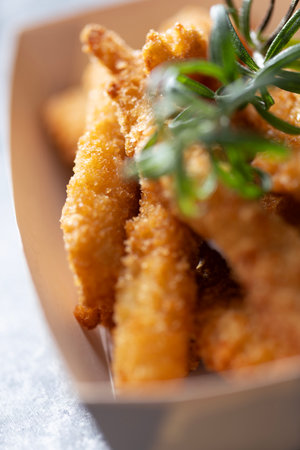 Close up of rustic pan fried breaded chicken tenders