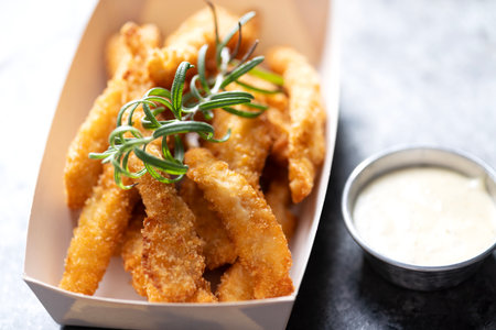Close up of rustic pan fried breaded chicken tendersの写真素材