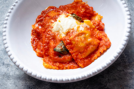 close up of a bowl of italian ravioli pasta in tomato sauceの写真素材
