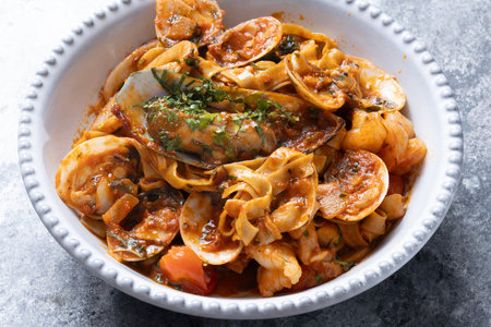 close up of a bowl of italian seafood pasta in tomato sauceの写真素材