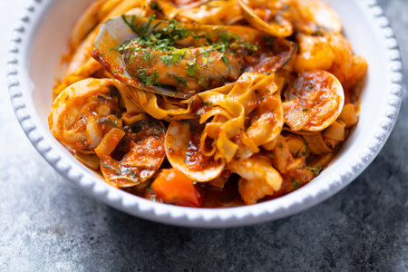 close up of a bowl of italian seafood pasta in tomato sauceの写真素材