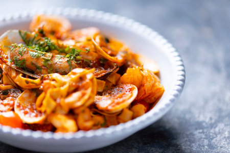 close up of a bowl of italian seafood pasta in tomato sauce