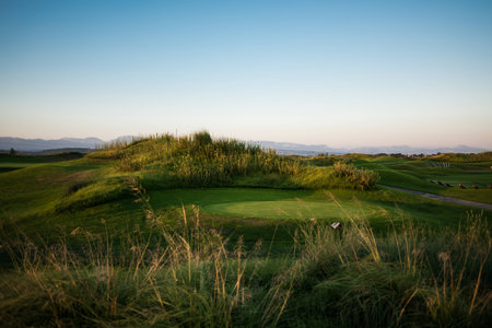 Beautiful golf course with collar at sunsetの写真素材