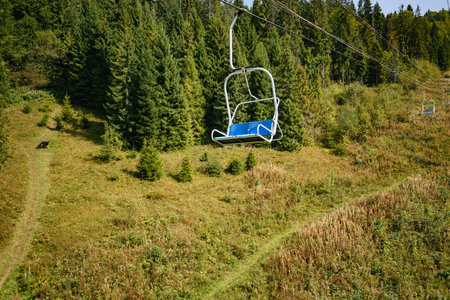 Lift seats in the Carpathians among spruce trees with walkway. Summer timeの写真素材
