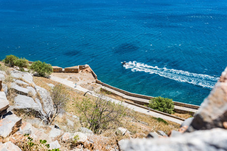 Top of Spinalonga island. View to ruins and blue aegian sea with boat. Lasithi, Greece.の写真素材