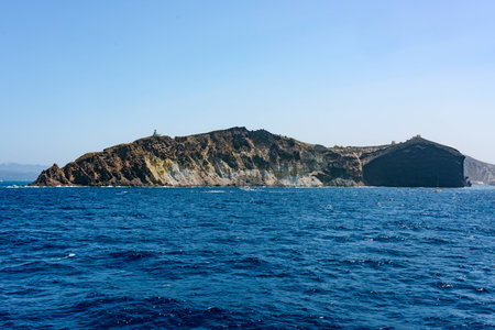 Rocky island on a deep blue sea with church. Santorini islands, Greece in summer.の写真素材