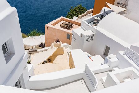 Tiny little white houses with cafes and pools in the Oia village at Santorini, Greece.の写真素材