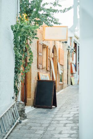 Tight street paved with stones with shops and cafes in the Lindos villageの写真素材