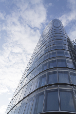 Glass modern building on a blue cloudy sky