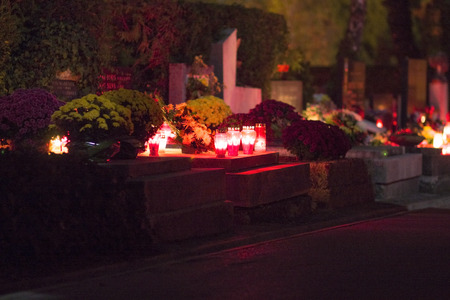 Burning candles on cemetery at nightの写真素材