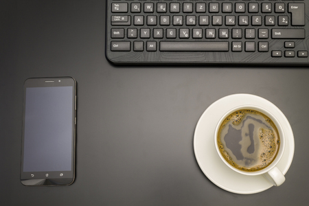 Office work space with phone,coffee and keyboardの写真素材