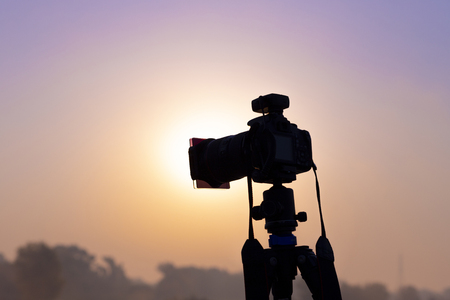 Camera on a tripod shooting at sunriseの写真素材
