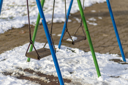 Empty swing in the park in winterの写真素材