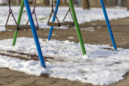 Empty swing in the park in winterの写真素材