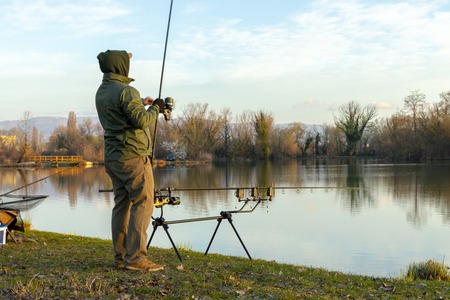 Fisherman doing carp fishing on a sunny morningの写真素材