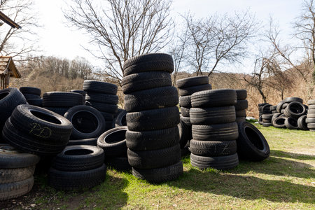 A pile of car tires in the house backyard on a sunny dayの写真素材