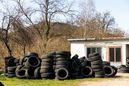 A pile of car tires in the house backyard on a sunny dayの写真素材