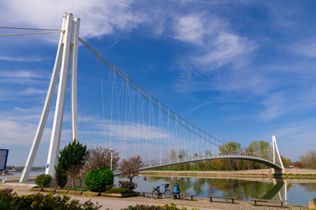 Pedestrian bridge over the Drava river and skyline of city of Osijek, Croatiaの写真素材
