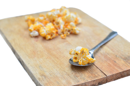 The piece of popcorn on the spoon and put on the block の写真素材