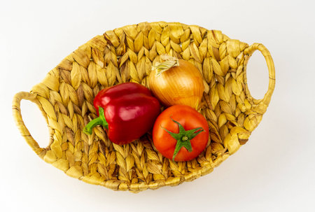 red peppers, onions and tomatoes are in the basket.の写真素材