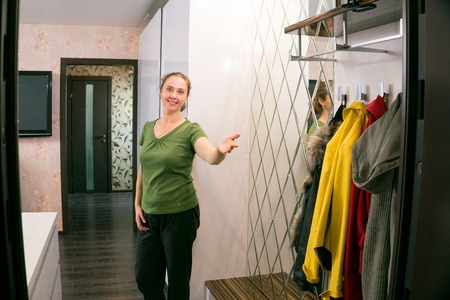 Woman opening her house door to welcome peopleの写真素材