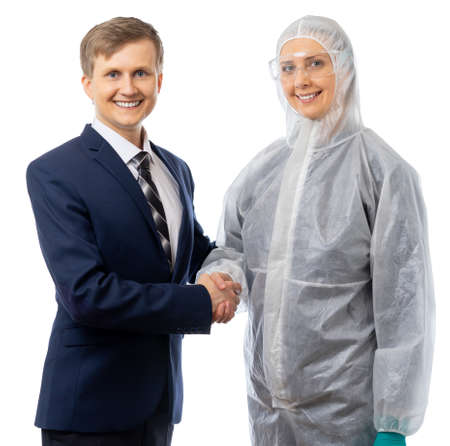 A businessman and a medic shake hands and look at the camera. The threat to humanity has been eliminated. They defeated the pandemic and the coronavirus epidemic. Isolated on a white background.の写真素材