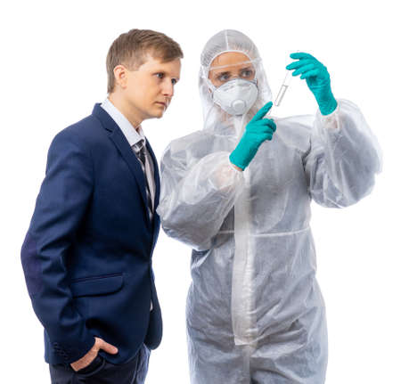 A scientist doctor in a protective suit shows an unknown liquid in a tube similar to a virus or...