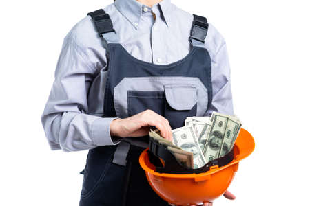 Builder engineer girl with money in a helmet. Isolatedの写真素材