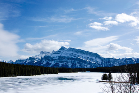 One fine day at frozen Minnewanka Lake with blue sky in early spring.の写真素材