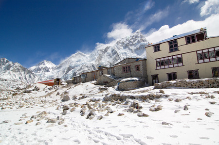 Gorak Shep, Everest Region, Nepal - March 19, 2010: The hotels in Gorak Shep village on snowy ground with high snow mountains behind in bright blue sky and white cloud.のeditorial素材