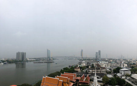 Bangkok cityscape, The Chao Phraya River crossed by a long bridge and skyscrapers along the...