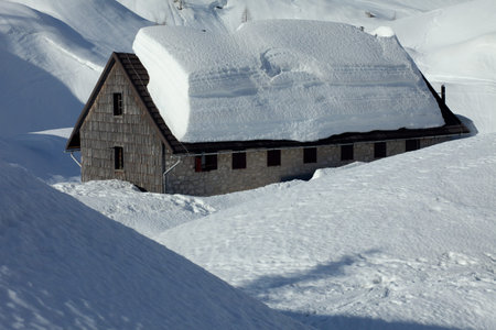 Winter house covered with layers of snow