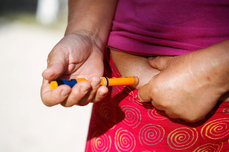 Woman injecting insulin to her bellyの写真素材