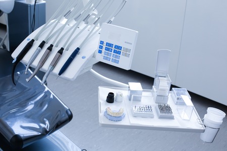 Dentist's office - specialist tools, drills, handpieces and laser with polish nozzles, drill nozzles and denture model on the trayの写真素材