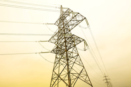 Pylons and power lines with yellow sky