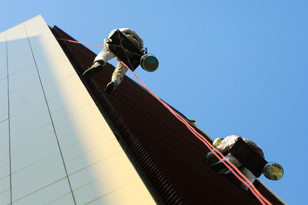 Two men working high on a buildingの写真素材
