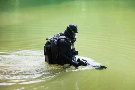 Scuba diver wearing full face mask entering lakeの写真素材