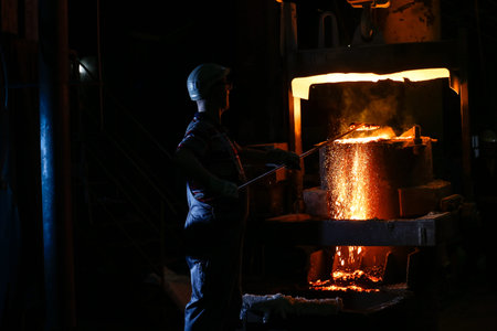 A founder holding a crucible of molten cast ironの写真素材