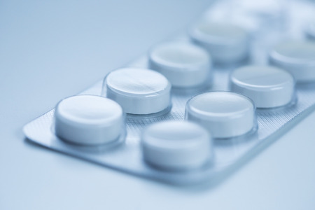 Medical pills in aluminium blister pack isolated on blue.の写真素材