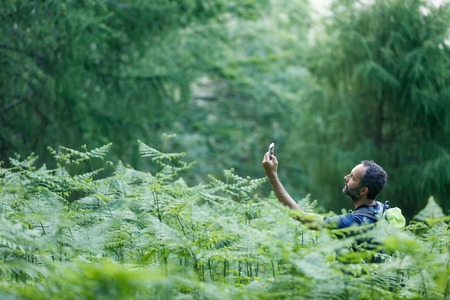 Hiker searching way to cache using global positioning deviceの写真素材