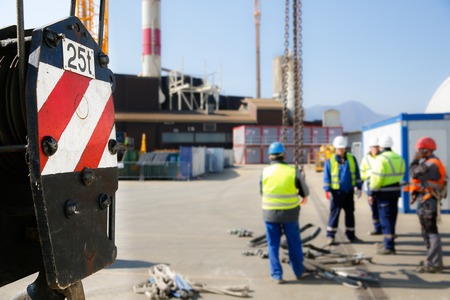 Pulley of a mobile lifting crane on a construction site, capable of lifting 25 tons of load with workers in the background. Heavy duty machinery for heavy construction industry.の写真素材