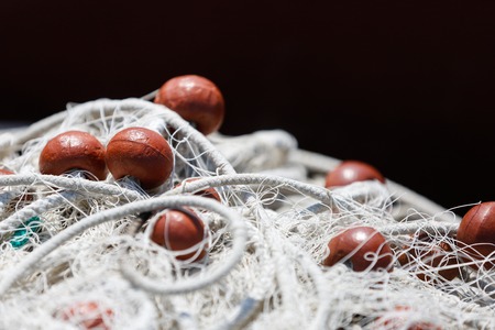 Fishing net with red floats on the float line, fisheries concept background, with space for your text.の写真素材