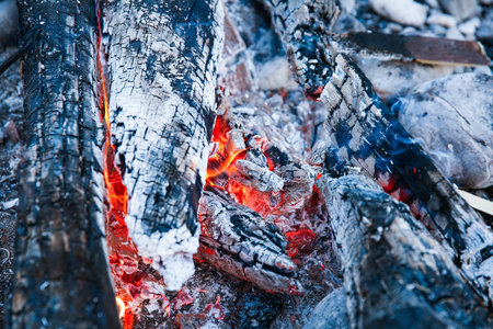 Embers of a self-made campfire, lit for cooking, roasting and water purification. Safety and...