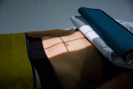 X-ray picture of a womans abdomen being taken after an injury. Medical procedures, diagnosis, technology, patients, emergency and injury concept.の写真素材