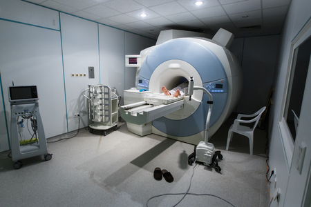 Patient being scanned and diagnosed on a MRI magnetic resonance imaging scanner in a hospital. Modern medical equipment, medicine and health care concept.の写真素材