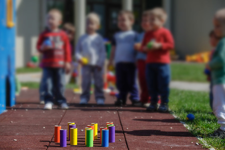 Children playing with homemade, do-it-yourself educational toys, tube bowling. Learning through experience concept, gross and fine motor skills, educational approach concept.の写真素材