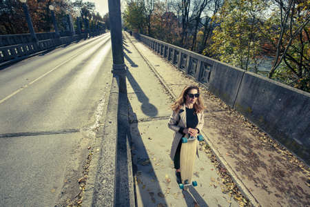 Active woman holding longboard. Urban lifestyle concept.の写真素材