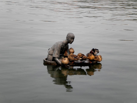 human & duck sculpture at the lakeの写真素材