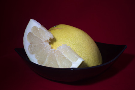 Sliced pomelo on a black plateの写真素材